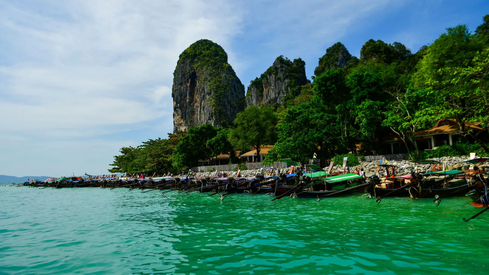Praia de Railay em Krabi com falésias de calcário e barcos de cauda longa