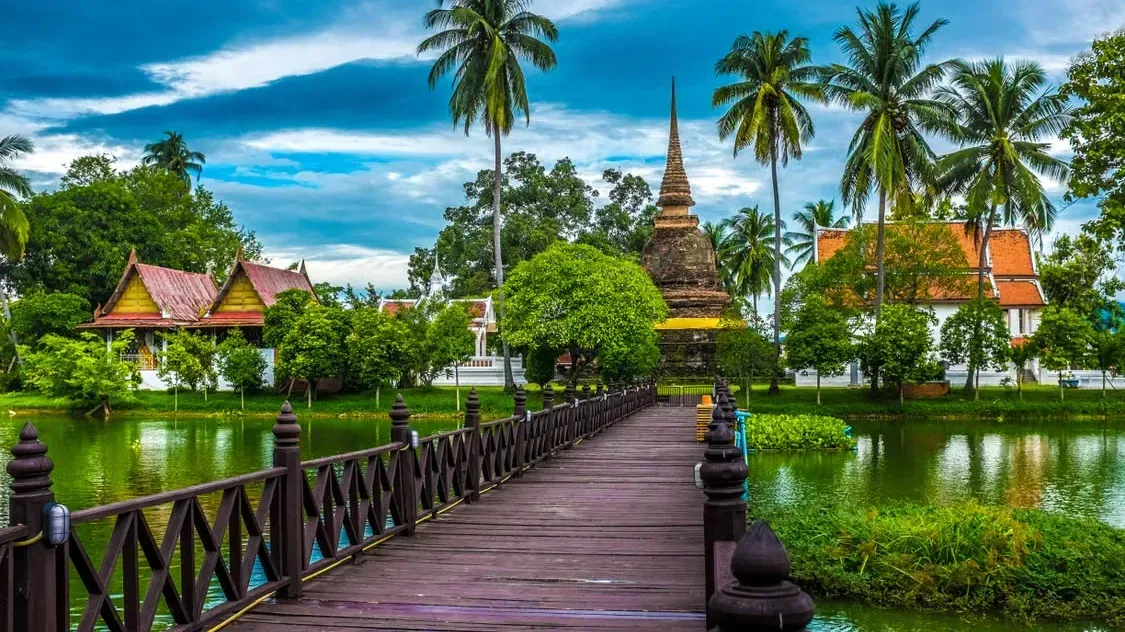 Templo e chedi junto a um lago em Sukhothai, na Região Central da Tailândia