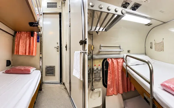 Trem 13 Bangkok a Chiang Mai – Cabine de Primeira Classe Cabine de primeira classe do trem 13 entre Bangkok e Chiang Mai, com camas, beliches e cortinas